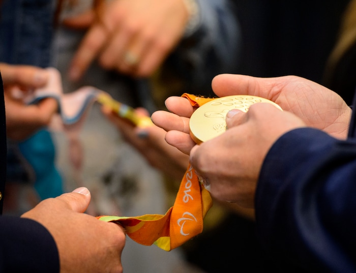 (Steve Griffin | The Salt Lake Tribune) 2018 Paralympic double gold medalist Brenna Huckaby lets guests hold her gold medals during a homecoming event for over 50 Utah connected Olympic and Paralympic athletes, prior to the seventh annual Governor's State of Sport Awards presented by Zions Bank and hosted by the Utah Sports Commission at Vivint Smart Home Arena in Salt Lake City Wednesday April 18, 2018. Huckaby won gold in the snowboard cross and banked slalom.