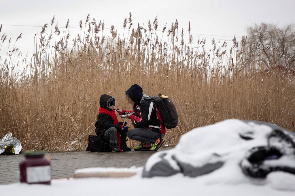 (Visar Kryeziu | AP) Tatiana Kostyuk, 38, from Zaporozhye, gives food to a child after fleeing Ukraine, at the border crossing in Medyka, Poland, Wednesday, March 9, 2022. The Utah Jazz Foundation announced it will fund 32,200 nights of housing for Ukrainian refugees through a partnership with the charitable arm of Airbnb.