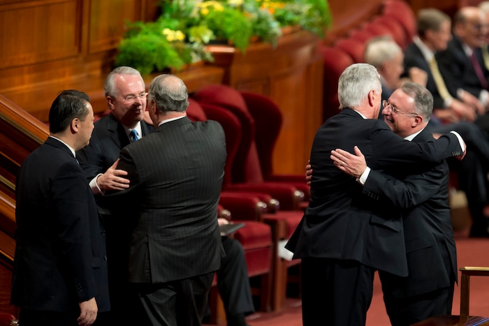(Jeremy Harmon  |  The Salt Lake Tribune)  Elder Dieter F. Uchtdorf and Elder Ulisses Soares embrace at the start of the Sunday afternoon session of General Conference on April 1, 2018.