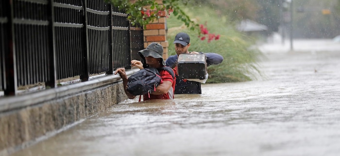 (David J. Phillip | The Associated Press) Residents wade through floodwaters from Tropical Storm Harvey Sunday, Aug. 27, 2017, in Houston, Texas.