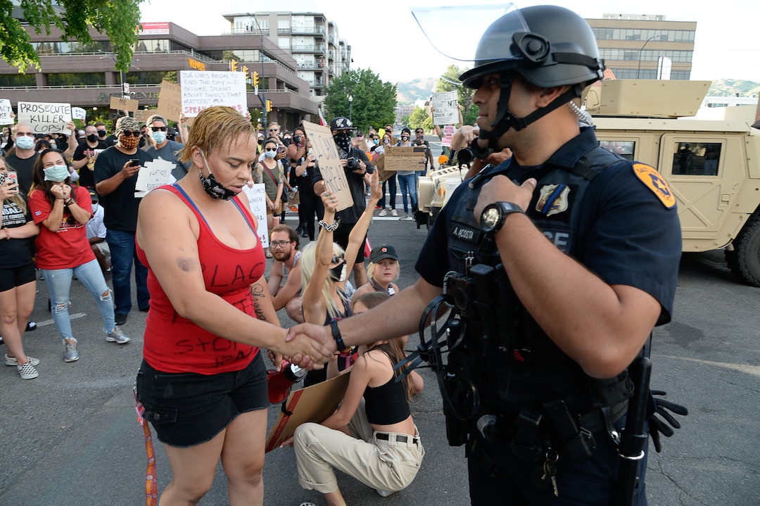(Francisco Kjolseth  |  The Salt Lake Tribune) Victoria Crosby with Black Lives Matter receives a hand shake from officer M. Acosta as demonstrators protest against police brutality on Tuesday, June 2, 2020, in downtown Salt Lake City, as an 8 p.m. weeklong curfew remains in order.