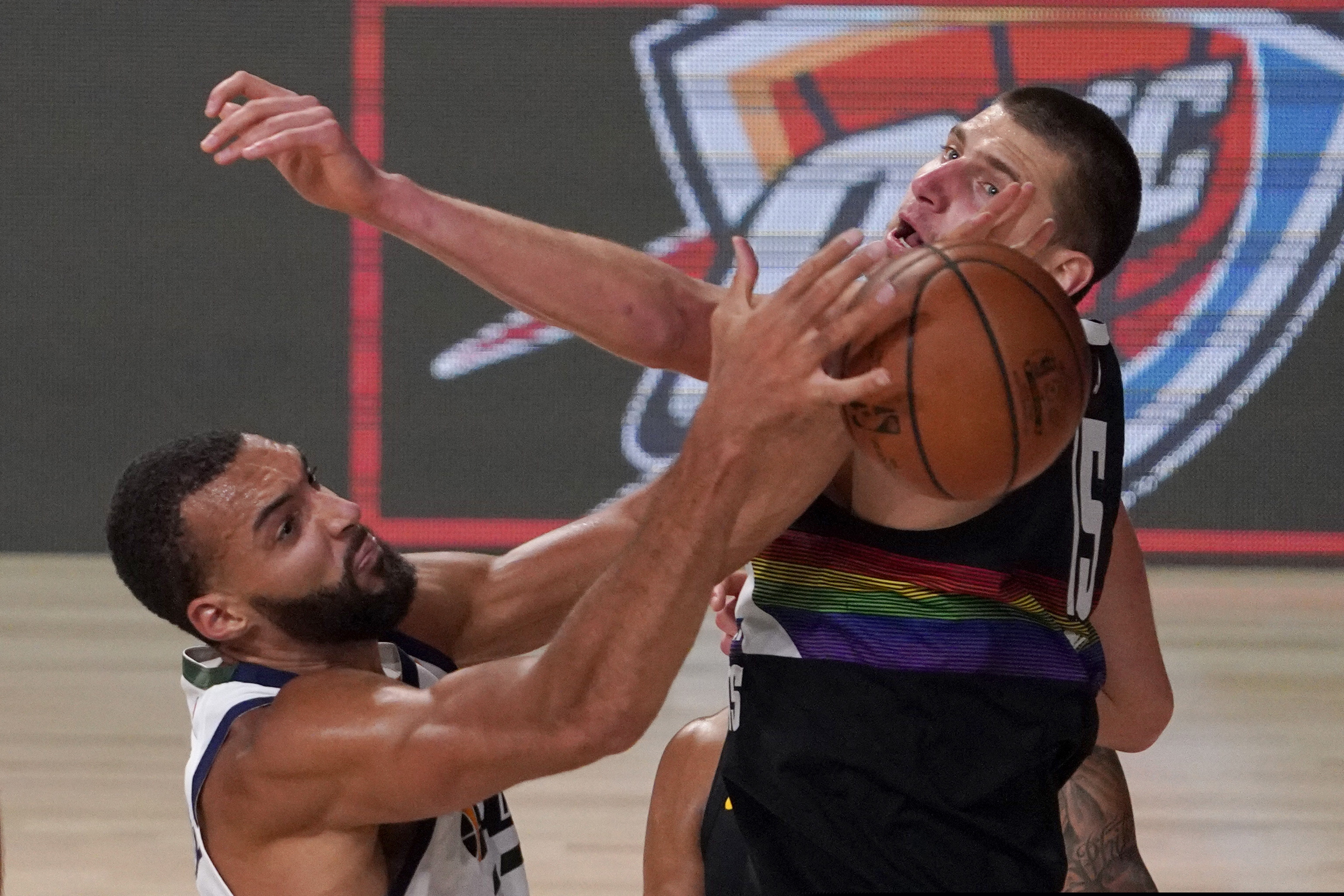 Utah Jazz's Rudy Gobert (27) grabs a rebound in front of Denver Nuggets' Nikola Jokic (15) during the second half an NBA first round playoff basketball game, Tuesday, Sept. 1,2020, in Lake Buena Vista, Fla. (AP Photo/Mark J. Terrill)