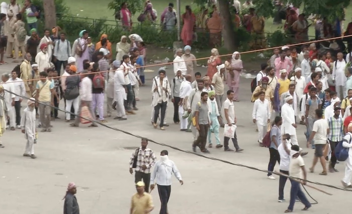 In this image made from video, supporters of an Indian guru who calls himself Saint Dr. Gurmeet Ram Rahim Singh Ji Insaan walk in the street as they react after his verdict was announced in Panchkula, India, Friday, Aug. 25, 2017. A north Indian court convicted the flamboyant leader of a quasi-religious sect of raping two of his followers, prompting thousands of supporters to shout angry protests and attack journalists covering Friday's verdict. (AP Photo)