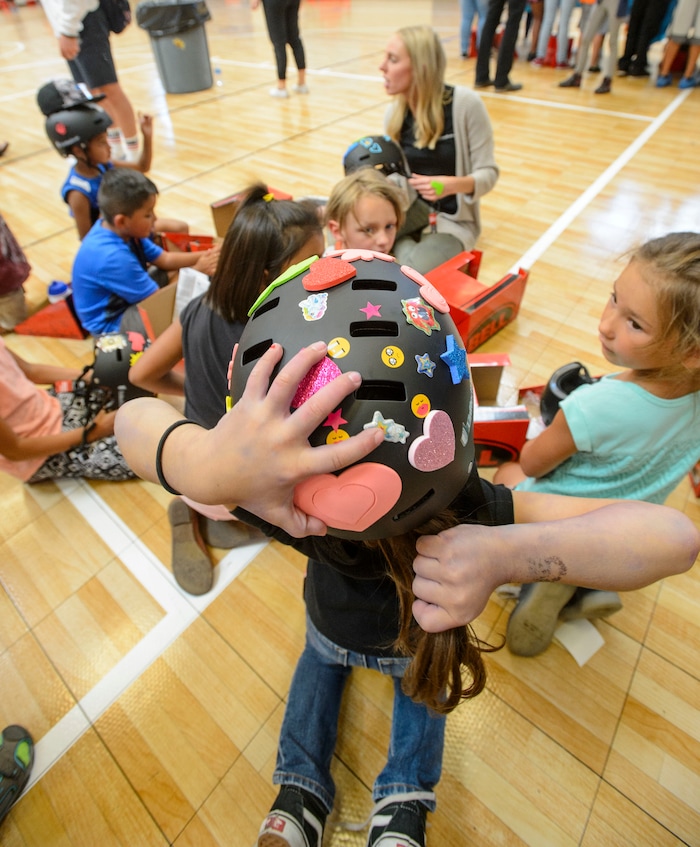 Steve Griffin  |  The Salt Lake TribuneAlexy Zepeda, 6, adjusts her pony tail as she wears her new bike helmet at the Lied Boys & Girls Club in Salt Lake City Friday July 28, 2017.  UnitedHealthcare donated helmets to help encourage kids and families to participate in the Tour of Utah kidsÕ events. Club youth will received the helmets and a helmet-fitting from UnitedHealthcare Pro Cycling Team members, as well as a lesson in helmet and bike safety.