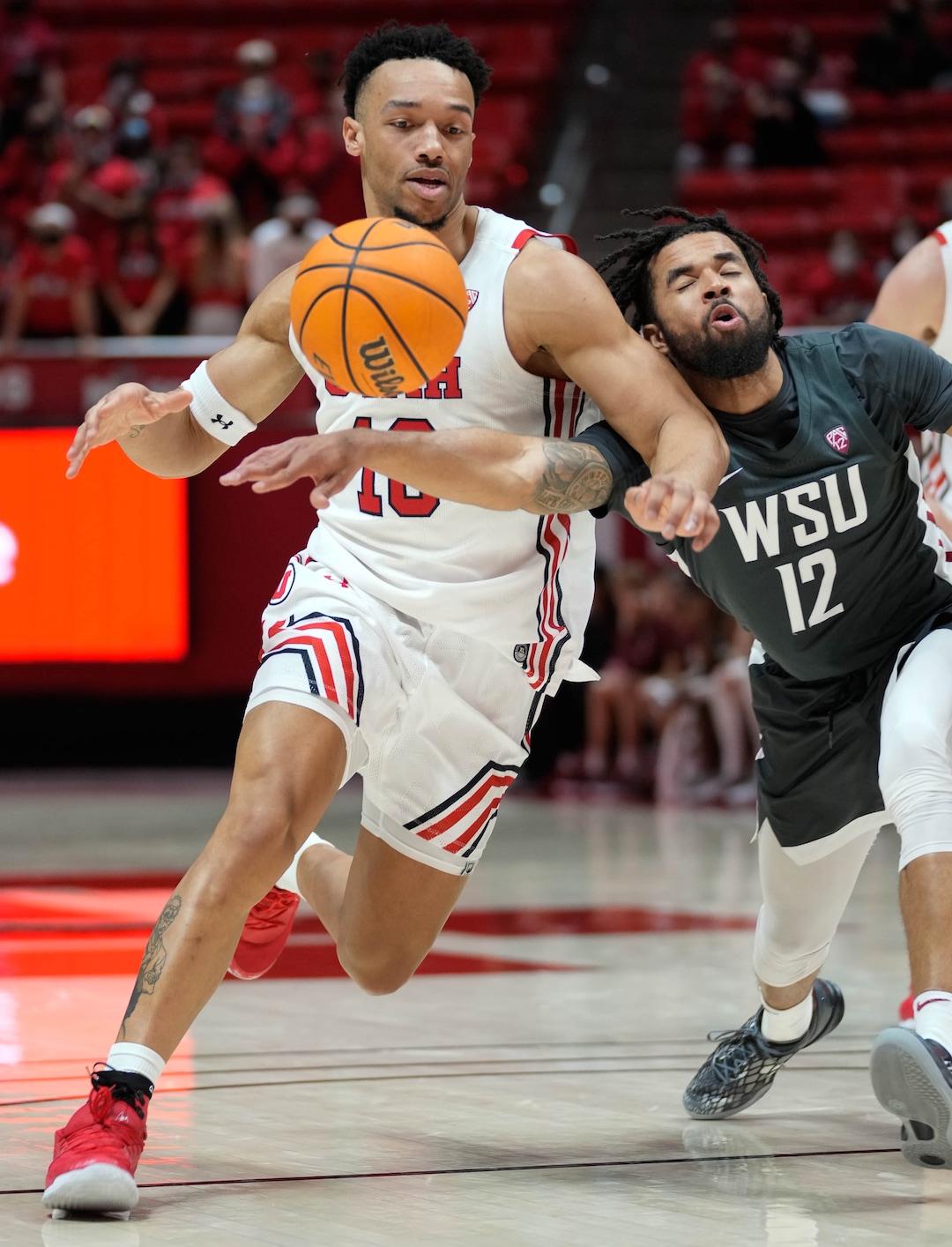 (Francisco Kjolseth | The Salt Lake Tribune) Washington State Cougars guard Michael Flowers (12) reaches in for the ball over Utah Utes guard Marco Anthony (10) in game action during an NCAA college basketball game at the Jon M.Huntsman Center, on Saturday, Jan. 8, 2022. Utah lost 61-77.