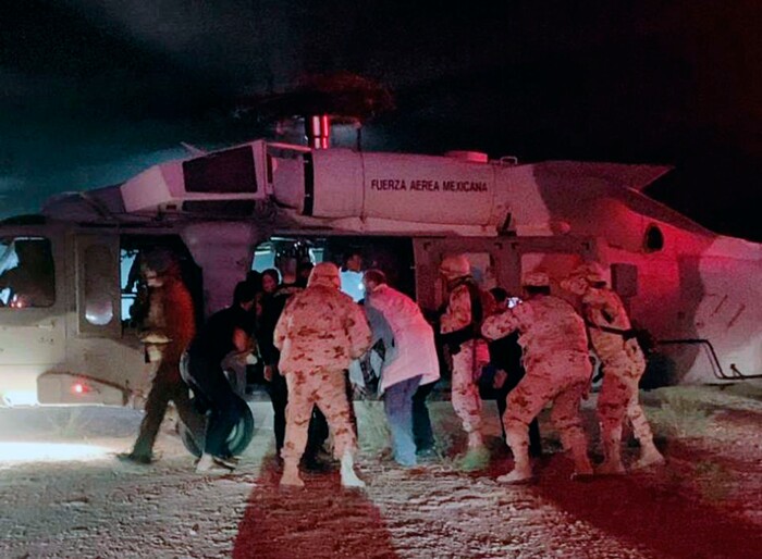 In this photo provided by the Sonora state Health Secretary, children of the extended LeBaron family, who were injured in an ambush are taken aboard a Mexican Airforce helicopter to be flown to the Mexico-U.S. border, from the border between the Mexican states of Chihuahua and Sonora, Monday, Nov.4, 2019. The children were injured when drug cartel gunmen ambushed three SUVs along a dirt road, slaughtering six children and three women, all U.S. citizens living in northern Mexico, in a grisly attack that left one vehicle a burned-out, bullet-riddled hulk. (Sonora state Health Secretary via AP)