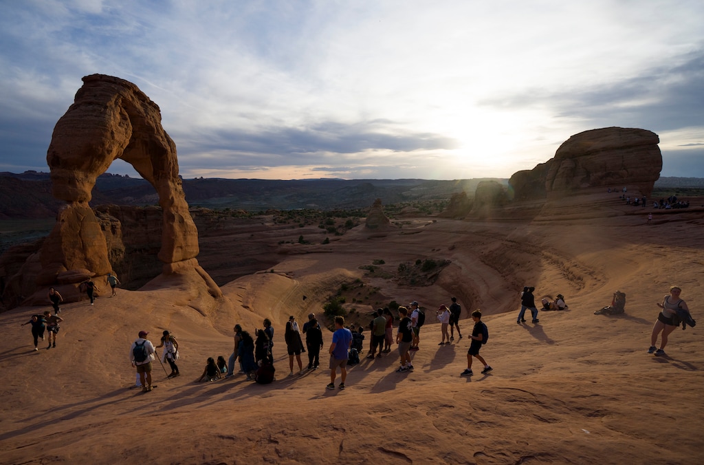 (Bethany Baker  |  The Salt Lake Tribune) People line up to take a photo under Delicate Arch inside Arches National Park near Moab on Thursday, April 9, 2026.