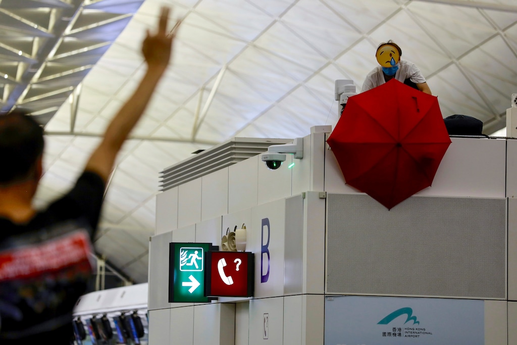 (Vincent Yu | AP file photo) A protester uses an umbrella to block a surveillance camera during a demonstration at the Airport in Hong Kong, on Tuesday, Aug. 13, 2019.