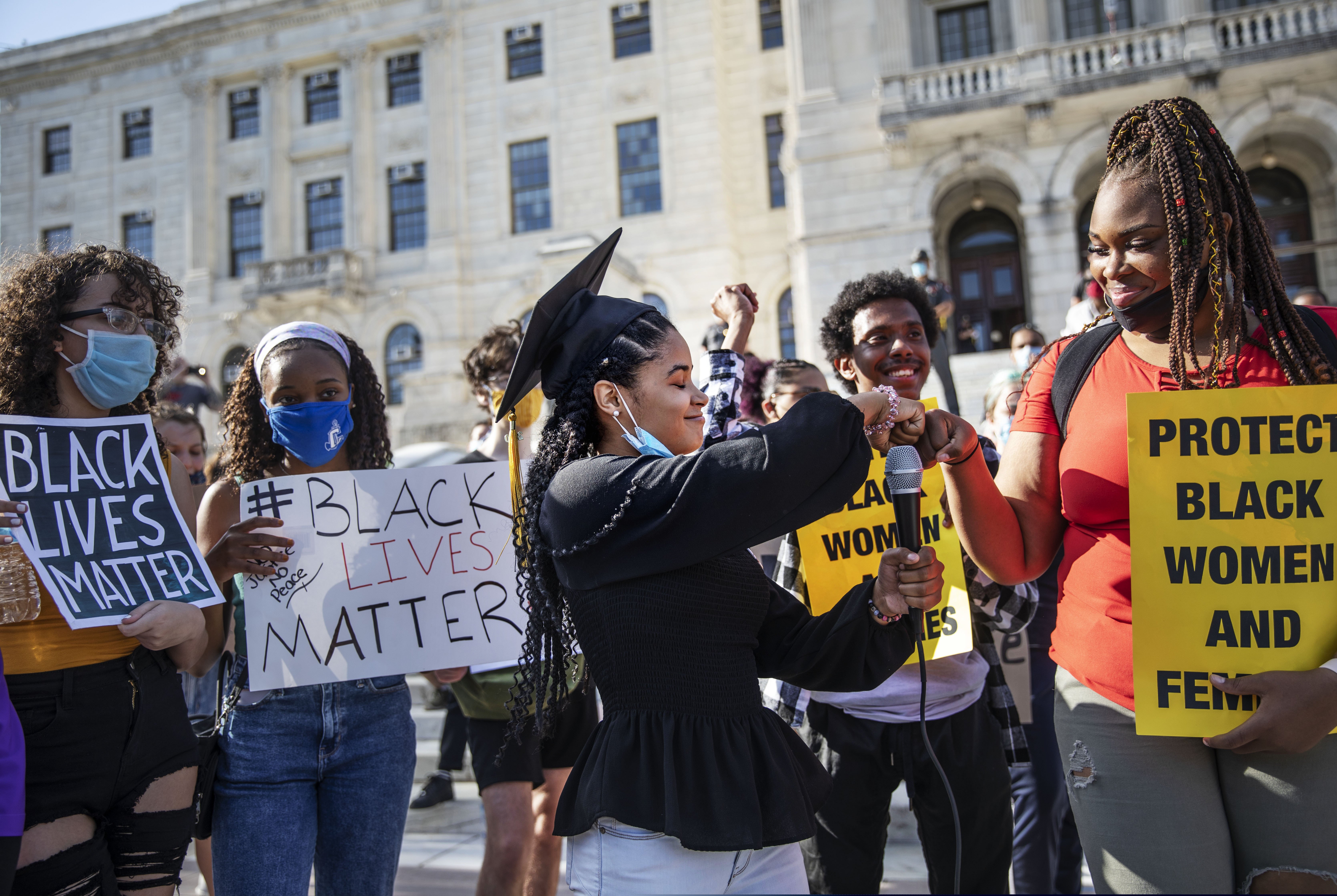(AP Photo/David Goldman)

Najeli Rodriguez, 18, center, wearing her cap from her high school graduation this year, fist bumps Amanda Toussaint, during a youth organized Juneteenth protest outside the Statehouse Friday, June 19, 2020, in Providence, R.I. Juneteenth commemorates when the last enslaved African Americans learned they were free 155 years ago. Now, with support growing for the racial justice movement, 2020 may be remembered as the year the holiday reached a new level of recognition.