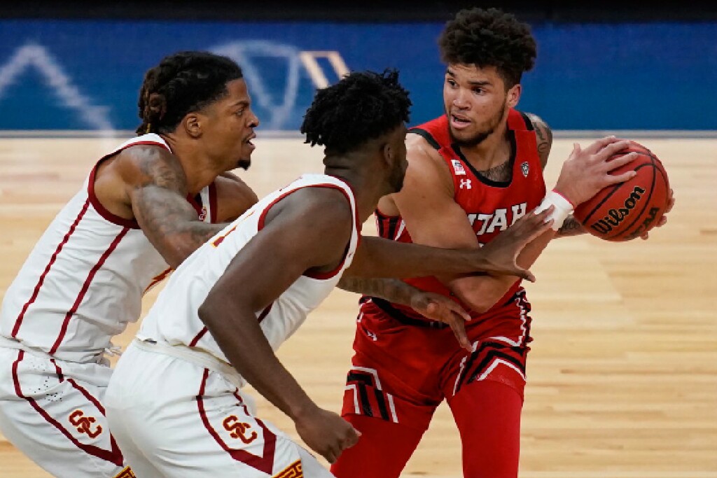 (John Locher | AP) Utah's Timmy Allen (1) looks to pass around Southern California's Chevez Goodwin, center, and Isaiah White during the first half of an NCAA college basketball game in the quarterfinal round of the Pac-12 men's tournament Thursday, March 11, 2021, in Las Vegas.