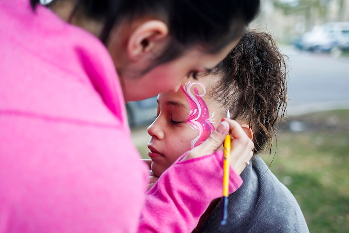 (Nicole Boliaux | For The Tribune) Kailee Brown, left, with My Kids Entertainment paints Aalyah Laeloni Milline's face during the annual Easter egg hunt put on by A Kid's Place Dentistry in Liberty Park in Salt Lake City on Saturday, March 31, 2018.