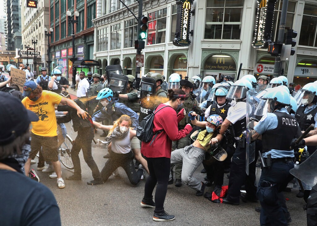 Chicago police use pepper spray on protesters at the corner of Randolph and Dearborn streets in downtown Chicago on Saturday, Aug. 15, 2020. The protesters are looking to defund the Chicago Police Department and to abolish ICE. (Chris Sweda/Chicago Tribune via AP)