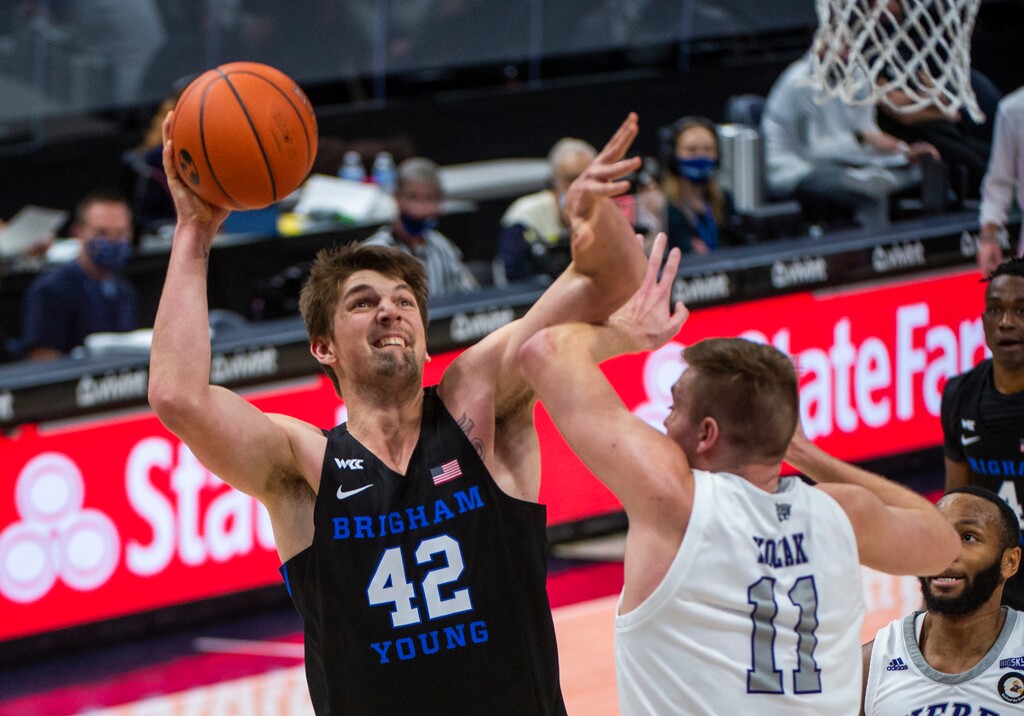 (Rick Egan | The Salt Lake Tribune) Brigham Young Cougars center Richard Harward (42) shoots as Weber State Wildcats forward Michal Kozak (11) defends, in basketball action between the Brigham Young Cougars and the Weber State Wildcats at Vivint Arena, on Wednesday, Dec. 23, 2020.