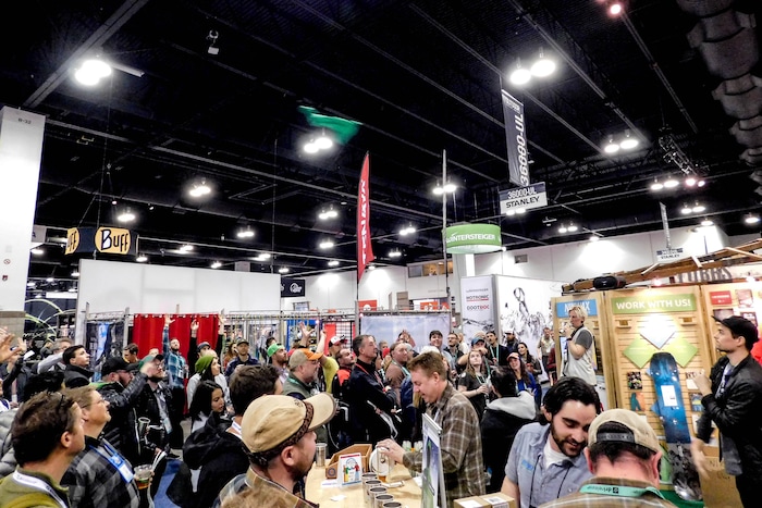(Erin Alberty | The Salt Lake Tribune) Outdoor Retailer attendees enjoy beer and reach for a free T-shirt  sailing over the crowd at the massive trade show Jan. 27, 2018 at the Colorado Convention Center in Denver.