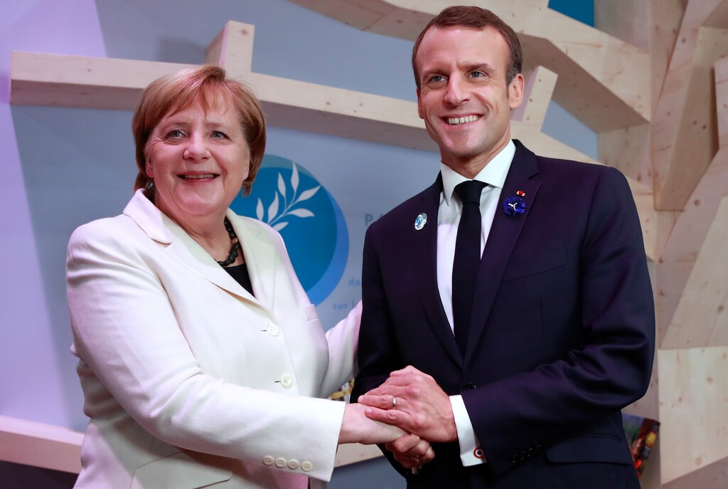 German Chancellor Angela Merkel and French President Emmanuel Macron hold hands after leaving books at the peace library of the Paris Peace Forum as part of the commemoration ceremony for Armistice Day, in Paris, Sunday, Nov. 11, 2018. International leaders attended a ceremony in Paris on Sunday at mark the 100th anniversary of the end of World War I. (Gonzalo Fuentes, Pool via AP)
