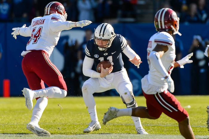 (Trent Nelson | The Salt Lake Tribune)  Brigham Young Cougars quarterback Joe Critchlow (11) prepares to get hit by Massachusetts Minutemen linebacker Leon Flanagan Jr. (54) as BYU hosts the University of Massachusetts, NCAA football in Provo, Saturday November 18, 2017.