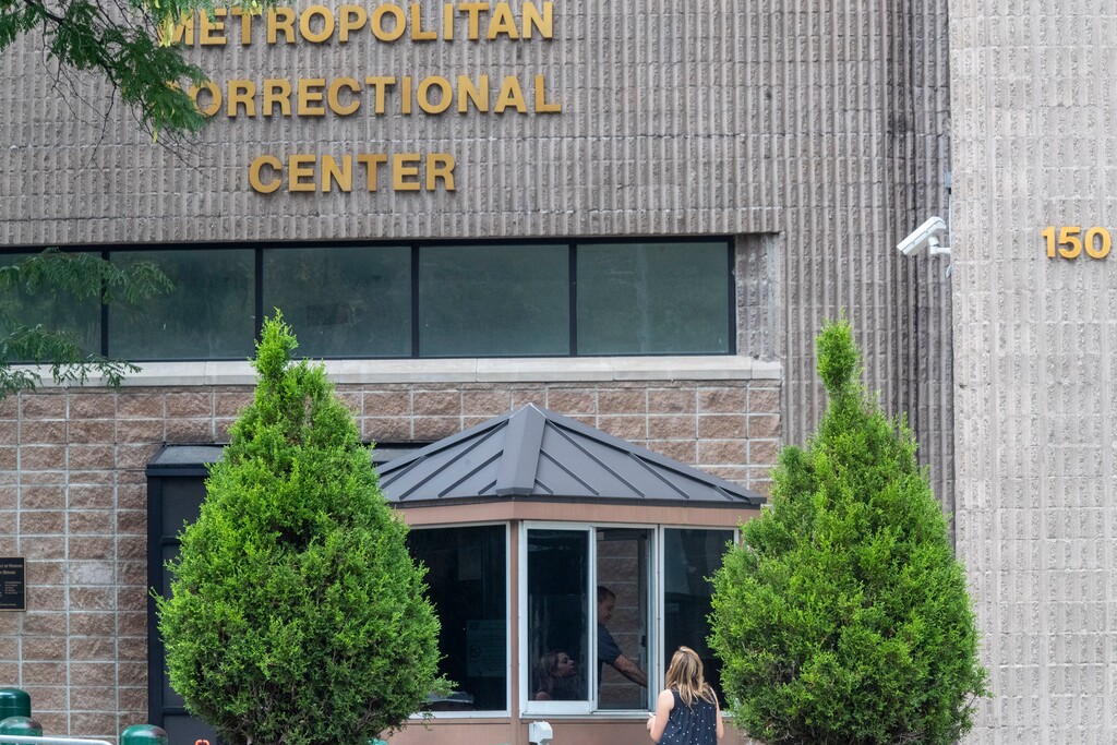 (Mary Altaffer | AP) An employee checks a visitor outside the Metropolitan Correctional Center, Tuesday, Aug. 13, 2019 in New York. The warden at the federal jail where Jeffrey Epstein took his own life was removed and two guards who were supposed to be watching the financier were placed on leave while federal authorities investigate the death.