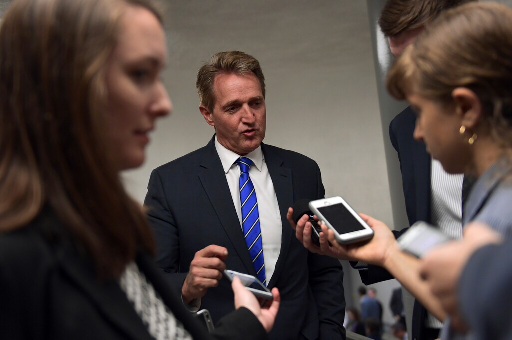 Sen. Jeff Flake, R-Ariz., is surrounded by reporters on his way to go vote on Capitol Hill in Washington, Tuesday, Nov. 7, 2017. (AP Photo/Susan Walsh)
