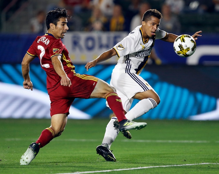 Los Angeles Galaxy forward Giovani dos Santos, right, chips the ball over Real Salt Lake defender Tony Beltran during the first half of an MLS soccer game in Carson, Calif., Saturday, Sept. 30, 2017. (AP Photo/Alex Gallardo)