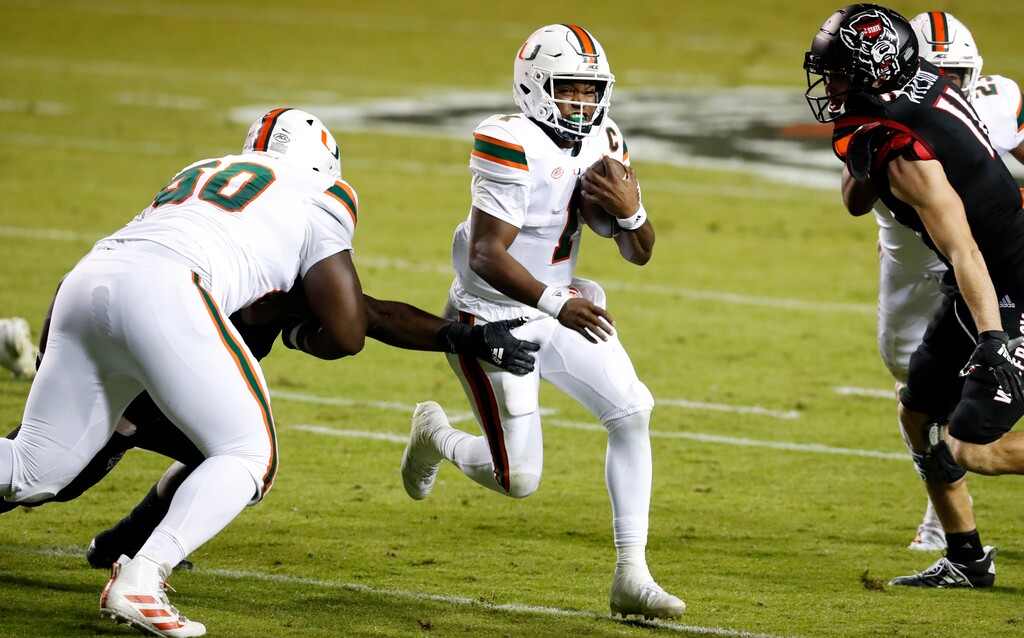 (Ethan Hyman | The News & Observer via AP) Miami quarterback D'Eriq King (1) runs past North Carolina State defenders last season. The Hurricanes will play a home-and-home against BYU, the Cougars announced Thursday.