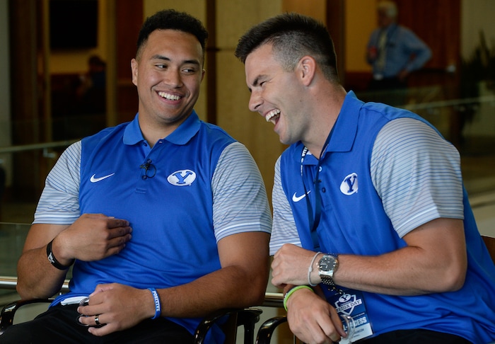 (Francisco Kjolseth  |  The Salt Lake Tribune)  Tight end Moroni Laulu-Pututau and quarterback Tanner Mangum share a laugh during an interview as part of the eighth-annual football media day at the BYU-Broadcasting Building on Friday, June 22, 2018.