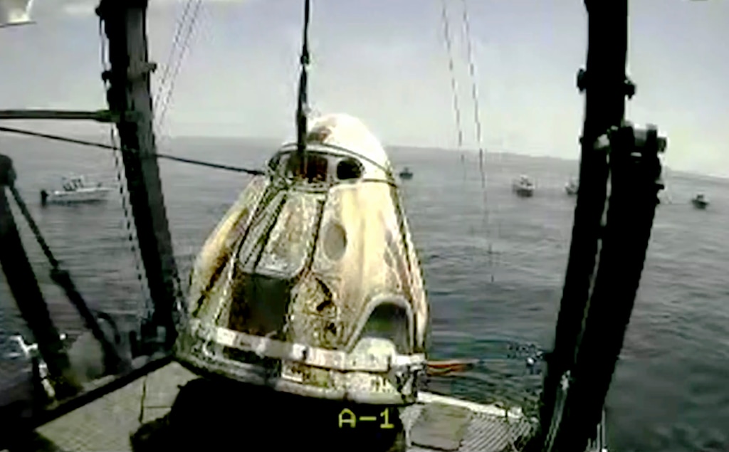 (NASA TV via AP) In this frame grab from NASA TV, the SpaceX capsule is lifted onto a ship, Sunday, Aug. 2, 2020 in the Gulf of Mexico. Astronauts Doug Hurley and Bob Behnken spent a little over two months on the International Space Station. It will mark the first splashdown in 45 years for NASA astronauts and the first time a private company has ferried people from orbit.