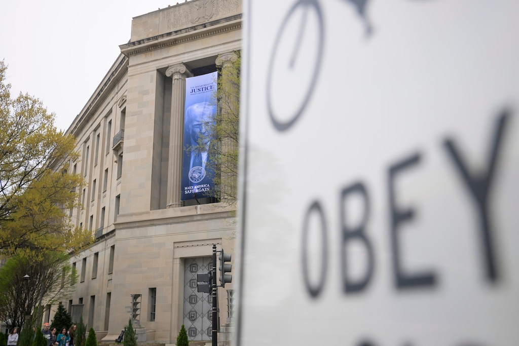 A banner featuring an image of President Donald Trump hangs on the Department of Justice in Washington, Thursday, April 2, 2026. (AP Photo/Rod Lamkey, Jr.)