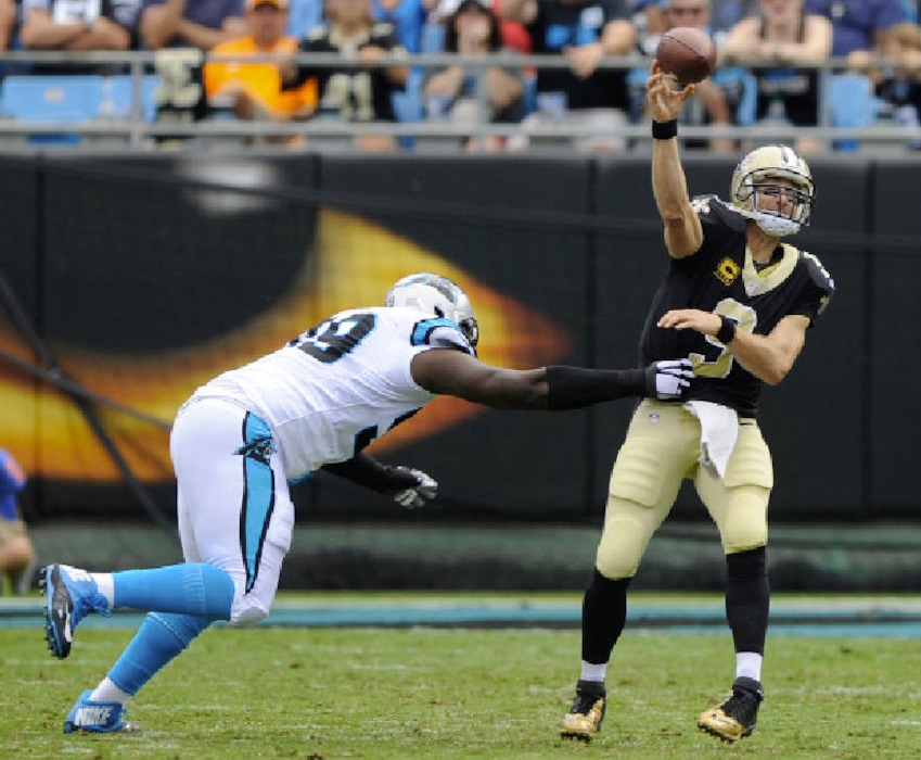 Mike McCarn | The Associated Press. New Orleans Saints' Drew Brees (9) throws a pass under pressure from Carolina Panthers' Kawann Short (99) in the first half of an NFL football game in Charlotte, N.C., Sunday, Sept. 24, 2017.