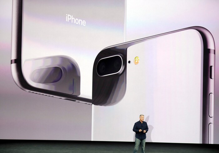 Phil Schiller, Apple's senior vice president of worldwide marketing, shows the new iPhone 8 at the Steve Jobs Theater on the new Apple campus on Tuesday, Sept. 12, 2017, in Cupertino, Calif. (AP Photo/Marcio Jose Sanchez)