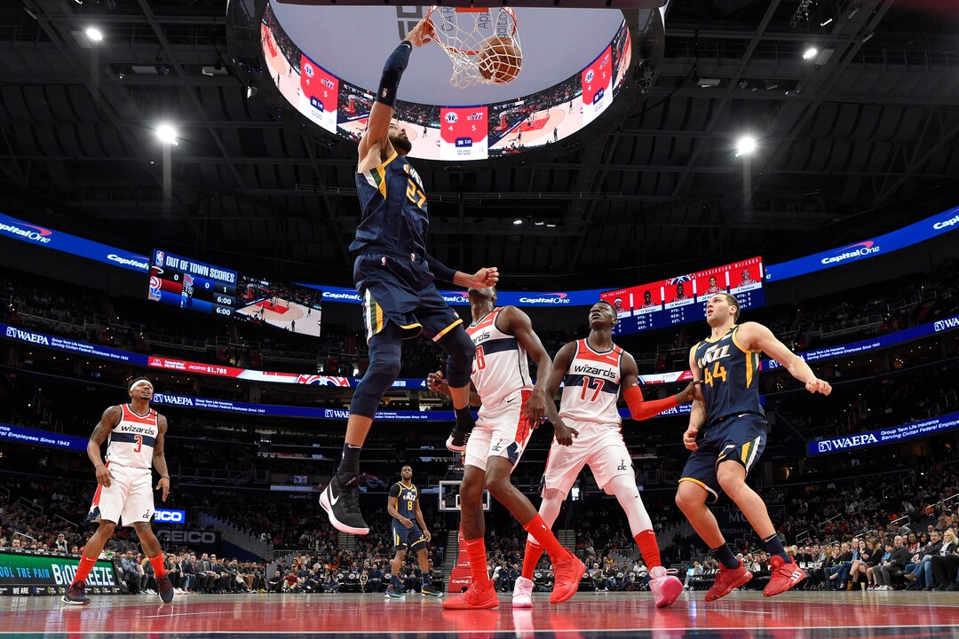 Utah Jazz center Rudy Gobert (27) dunks during the first half of an NBA basketball game next to Washington Wizards center Ian Mahinmi (28) and guard Isaac Bonga (17), Sunday, Jan. 12, 2020, in Washington. The Jazz won 127-116. (AP Photo/Nick Wass)