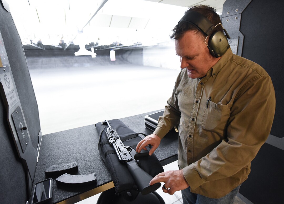 (Francisco Kjolseth  |  The Salt Lake Tribune)  Utah gun rights advocate Clark Aposhian, one of only a handful of Americans who are legally allowed to keep their bump stock, a shooting accessory that alters semi-automatic rifles to fire in quick bursts like a machine gun, demonstrates how it works on an AKM-47 at a gun range in Murray, UT, on Thursday, April 4, 2019. He is challenging the bump stock ban in court, and an appeals court has allowed him to keep his bump stock until his case is resolved in court.
