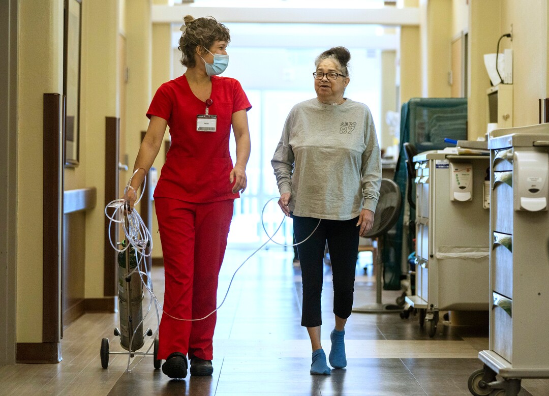 (Rick Egan | The Salt Lake Tribune) Heidi Weiler assists Tina Lewis as she gets some exercise walking the halls of South Davis Community Hospital in Bountiful, on Tuesday, Sept. 21, 2021.