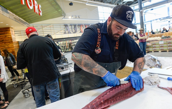 (Francisco Kjolseth  |  The Salt Lake Tribune)  Matthew Cheatham filets an 80 lbs Yellow Fin tuna during opening day of the new Whole Foods Market in Park City on Wednesday, Oct. 18, 2017. 