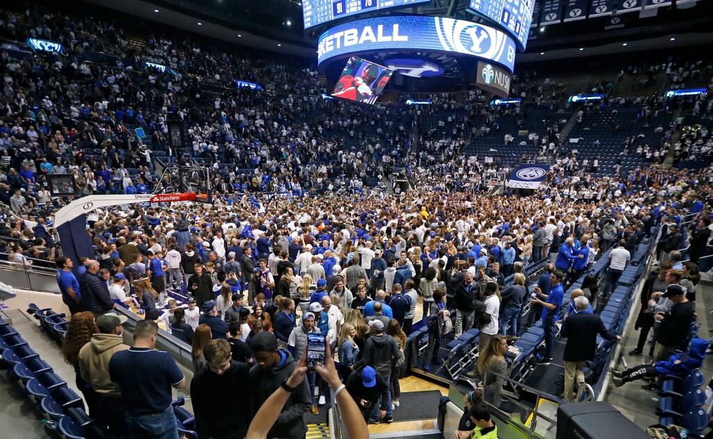 FILE - In this Feb. 22, 2020, file photo, BYU students and fans celebrate on the court following their victory over Gonzaga following an NCAA college basketball game, in Provo, Utah. Utah public health officials are contacting and testing BYU basketball fans who sat near a coronavirus patient at a game prior to the infection being diagnosed, the university said Monday, March 9, 2020. He had mild symptoms and there's little risk the virus was transmitted more widely the Feb. 22 game against Gonzaga, the school said in a statement. People who went to the game don't need to do anything unless the are contacted by the Utah County Health Department. (AP Photo/Rick Bowmer, File)
