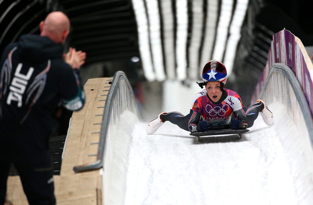 (Doug Mills | The New York Times) Skeleton athlete Katie Uhlaender looks to her coach as she comes to a stop after a race in Krasnaya Polyana, Russia, Feb, 14, 2014. Uhlaender, who is still competing, wonders whether symptoms like mental fog, headaches, inability to eat or speak effectively, and sensitivity to light and sound that a day of training, or, for some, even a single routine run can produce, are connected to their dramatic crashes and the brain rattling runs.