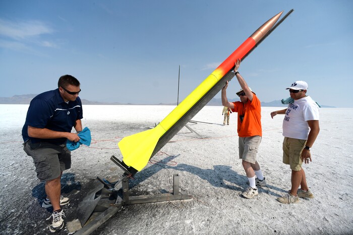 (Scott Sommerdorf   |  The Salt Lake Tribune)   David Spencer, center, and his helpers Jamie and Brett Borget prepare Spencer's rocket for launch at "HellFire" — the event sponsored by the Utah Rocket Club on Saturday, Aug. 5, 2017.