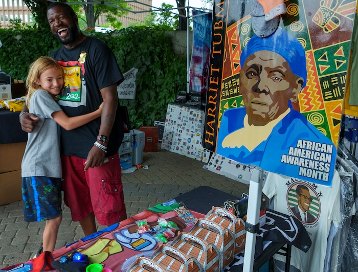 (Leah Hogsten | The Salt Lake Tribune) Kevy Kev, right, gets a hug from Leo Murray, 9, who was given a free "Among Us" bag from Kev at the Utah Juneteenth Celebration at the Ogden City Amphitheater, Saturday, June 18, 2022. 