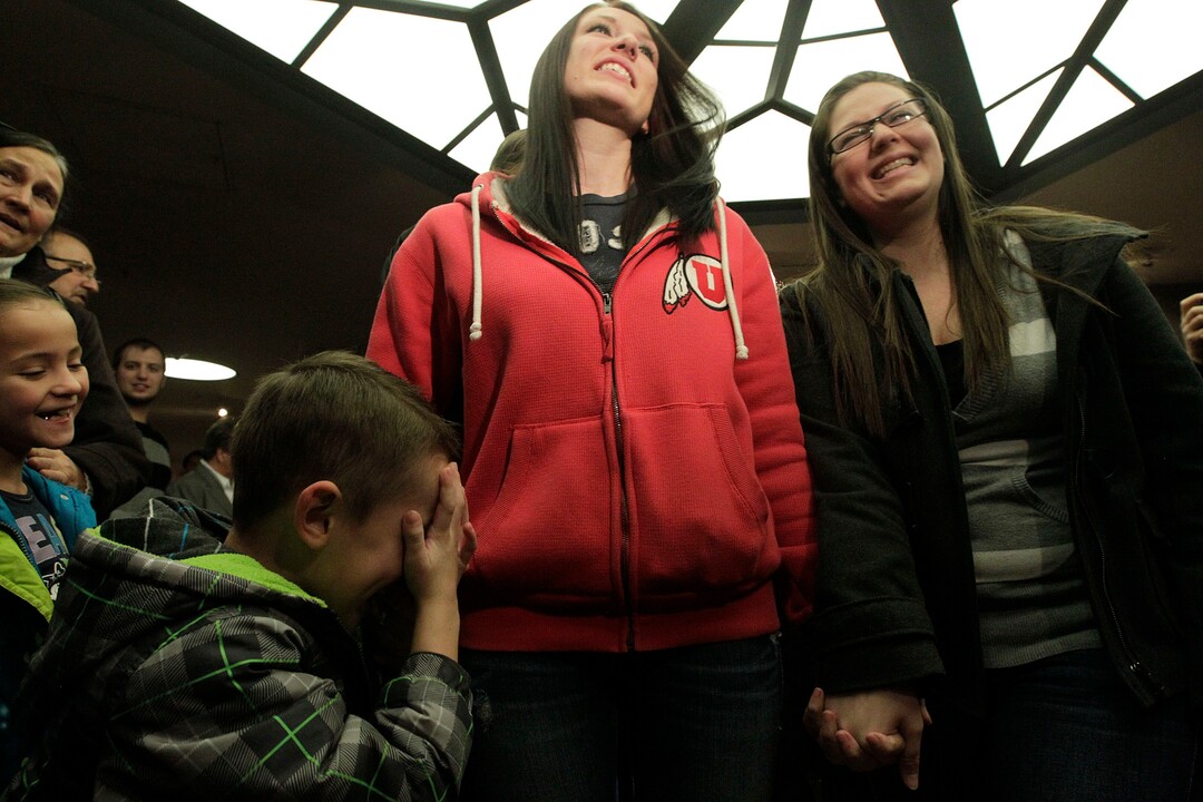 Leah Hogsten  |  The Salt Lake Tribunel-r Chantel Buhler and spouse Laura Fernandez  giggle at their son Kayson, 4, after the two were officially married by the Rev. Curtis L. Price in the lobby of the Salt Lake County offices, Friday December 20, 2013. Several hundred people descended on the Salt Lake County ClerkÕs Office Friday afternoon to get licenses. U.S. District Court Judge Robert J. Shelby in Utah Friday struck down the stateÕs ban on same-sex marriage, saying the law violates the U.S. ConstitutionÕs guarantees of equal protection and due process.