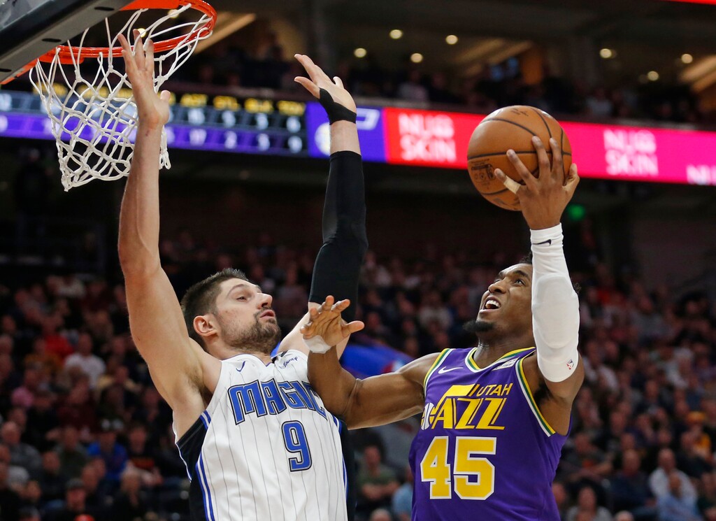 Utah Jazz guard Donovan Mitchell (45) goes to the basket as Orlando Magic center Nikola Vucevic (9) defends during the second half of an NBA basketball game Wednesday, Jan. 9, 2019, in Salt Lake City. (AP Photo/Rick Bowmer)