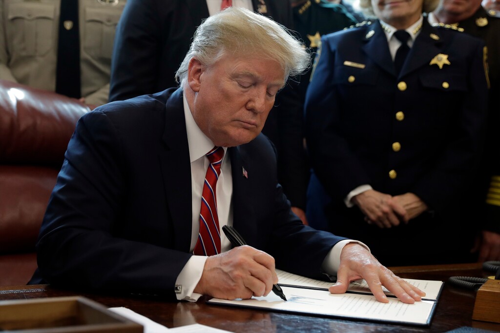 FILE - In this March 15, 2019, file photo, President Donald Trump signs the first veto of his presidency in the Oval Office of the White House in Washington. Trump issued the first veto, overruling Congress to protect his emergency declaration for border wall funding. Trump is nearing a victory over Democrats as the House tries overriding his first veto. Tuesday’s vote seems certain to fail, which means his declaration of a national emergency at the Mexican border would stand. (AP Photo/Evan Vucci, File)
