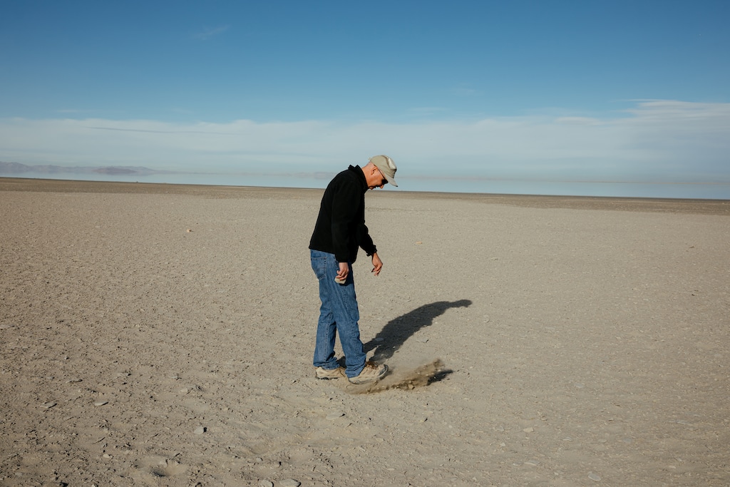 (Bryan Tarnowski/The New York Times) Kevin Perry, a professor of atmospheric studies at the University of Utah, walks on land that used to be submerged by the Great Salt Lake in Utah, March 15, 2022. Climate change and rapid population growth are shrinking the lake, creating a bowl of toxic dust that could poison the air around Salt Lake City.