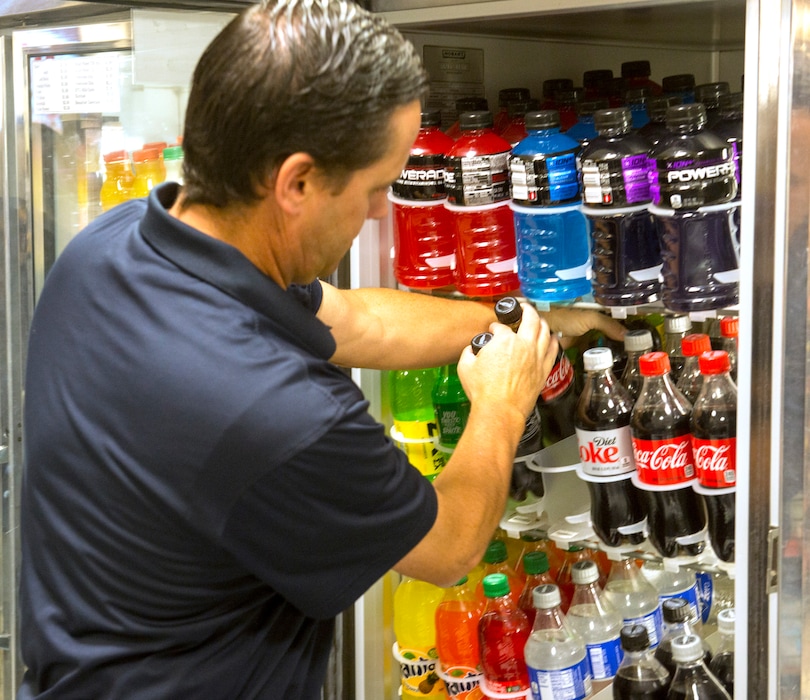 (Rick Egan  |  The Salt Lake Tribune)  A BYU food services employee stocks caffeinated Coca-Cola products in the cooler at the Cougar Express on BYU campusThursday, September 21, 2017.