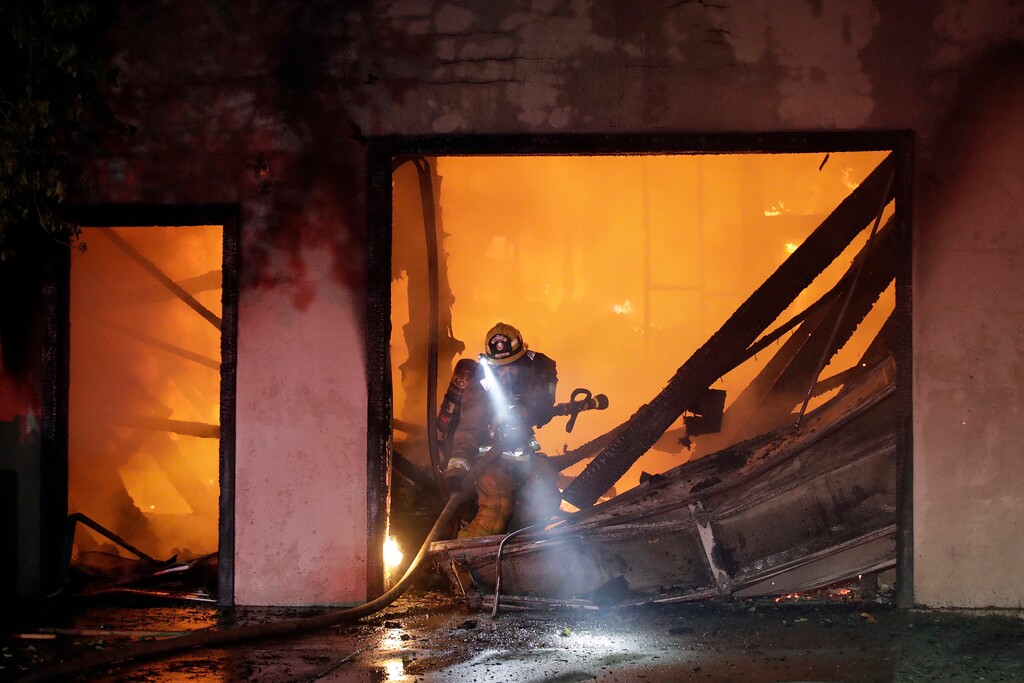 (Marcio Jose Sanchez | AP) A firefighter works the scene of a wildfire-ravaged home Thursday, Oct. 24, 2019, in Santa Clarita, Calif. Fast-growing fires across California have forced thousands of people to evacuate as dry winds and high heat feed the flames.
