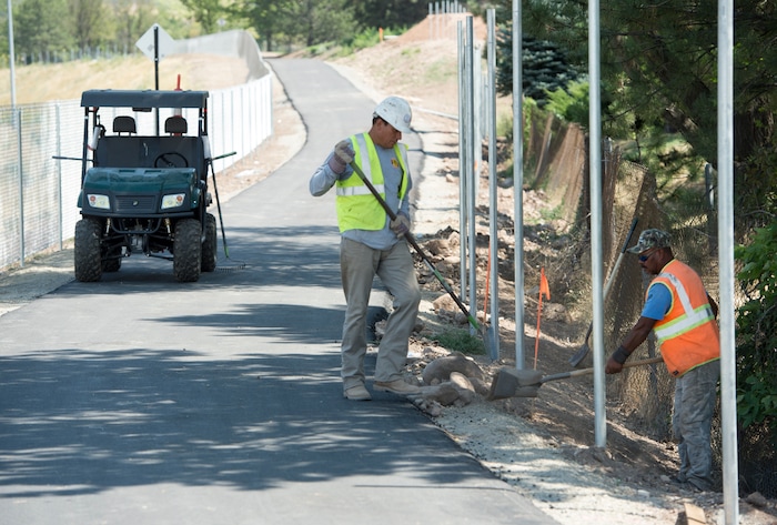 (Rick Egan | The Salt Lake Tribune) Victor Lemus and Joe Gonzalez work to install a chain-link fence on a new segment of Parley's Trail in Salt Lake City on Wednesday, Aug. 30, 2017.