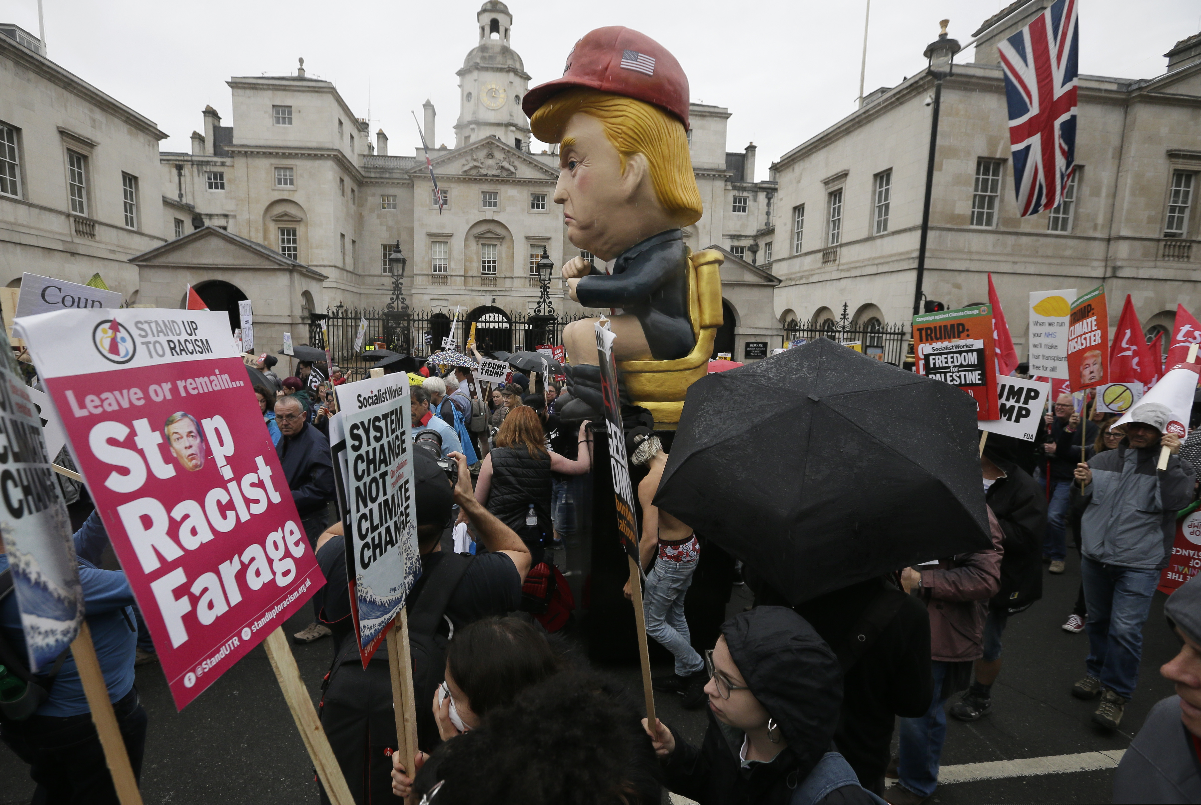 People carry signs and banners as they march through central London to demonstrate against the state visit of President Donald Trump, Tuesday, June 4, 2019. Trump will turn from pageantry to policy Tuesday as he joins British Prime Minister Theresa May for a day of talks likely to highlight fresh uncertainty in the allies' storied relationship. (AP Photo/Tim Ireland)