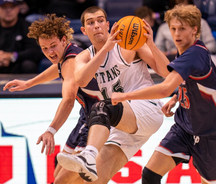 (Rick Egan | The Salt Lake Tribune) 
Olympus Titan, center, Jack Wistrcill (15) grabs a pass, as Woods Cross forward Nic Hogan (34) and Alex Brey (25) defend, in the 5A State Championship game between Woods Cross and Olympus, at the Marriott Center in Provo, on Saturday, March 5, 2022. 