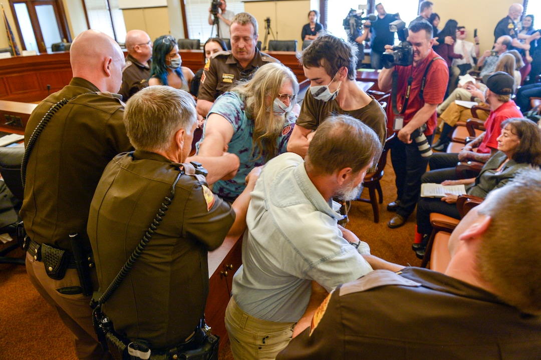 (Leah Hogsten  |  The Salt Lake Tribune) Opponents of the proposed inland port are escorted out of the Utah Inland Port Authority Board meeting by Utah Highway Patrol officers at the Capitol, June 5, 2019. The Inland Port Authority Board had to cancel its meeting last month after a group of protesters took over the meeting.