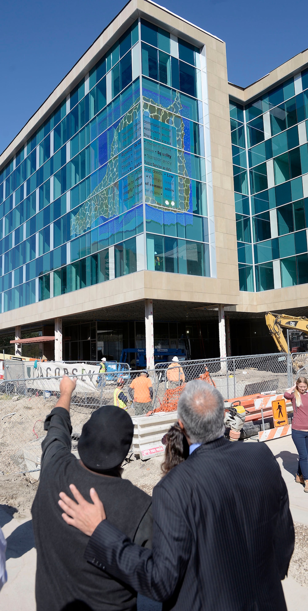 (Al Hartmann  |  The Salt Lake Tribune) 	
Artist Gordon Huether, left, and Salt Lake County District Attorney Sim Gill look at the detail of the new glass art covering the façade of the downtown District Attorney building at 35 E. 500 S. in Salt Lake City.  It was unveiled Wednesday September 27.    The glass artwork is complete, but the building is currently under construction to be completed in Spring 2018.
