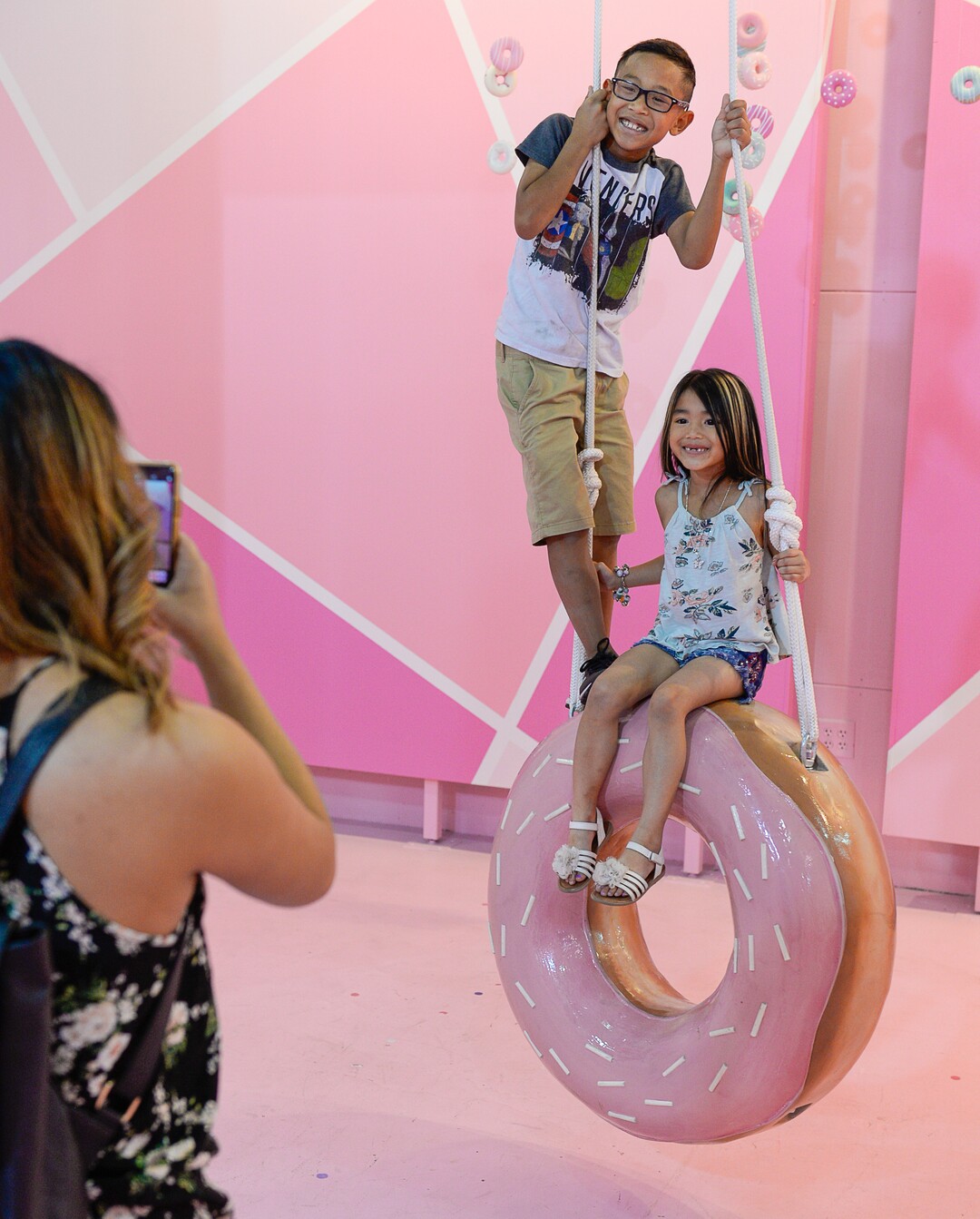 (Francisco Kjolseth  |  The Salt Lake Tribune)  Jaeden and Danika Thackin pose for their mother, Sam Bansasine, in the donut room at Hall of Breakfast, a quirky new art exhibit that celebrates the first meal of the day. It runs through July 9 at The Gateway.