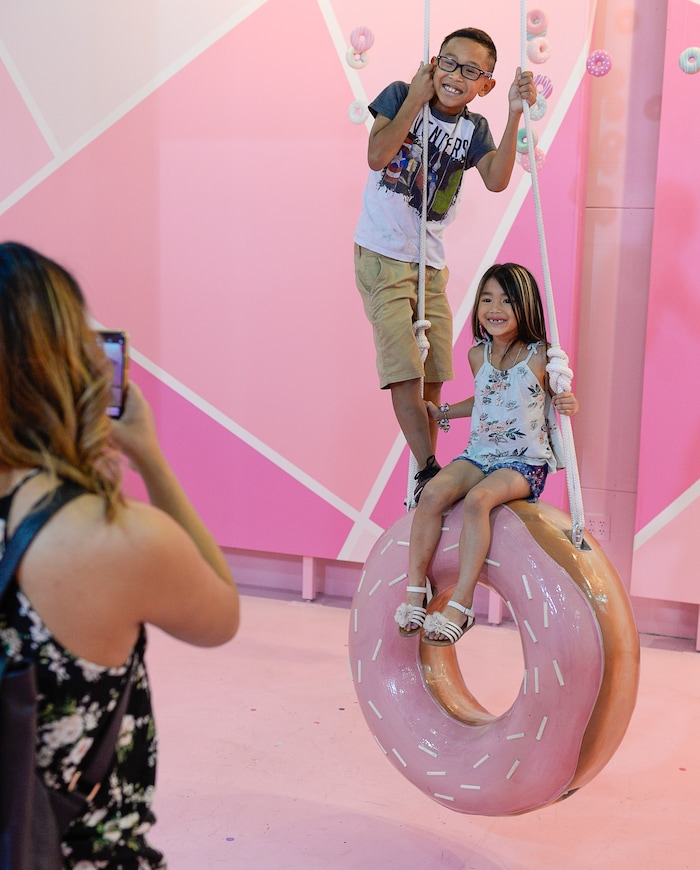 (Francisco Kjolseth  |  The Salt Lake Tribune)  Jaeden and Danika Thackin pose for their mother, Sam Bansasine, in the donut room at Hall of Breakfast, a quirky new art exhibit that celebrates the first meal of the day. It runs through July 9 at The Gateway.